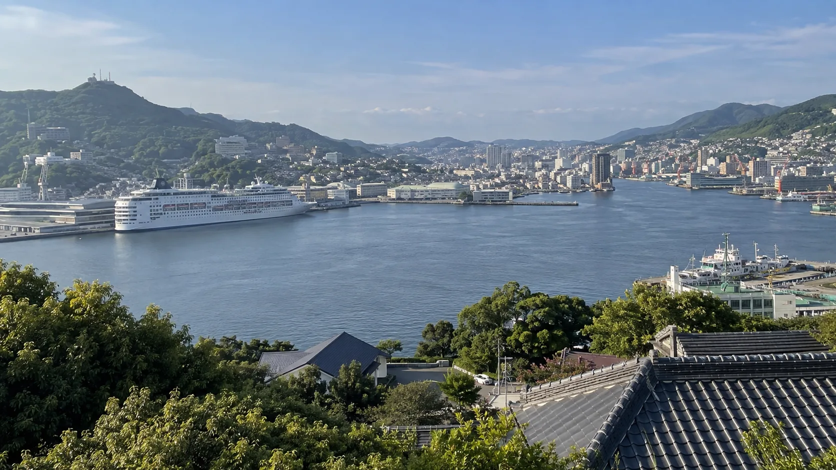 Nagasaki cruise terminal and city harbor surrounded by hills.
