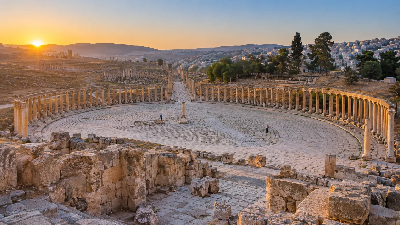Jerash's oval plaza and sweeping Roman colonnades glowing at sunrise in northern Jordan.