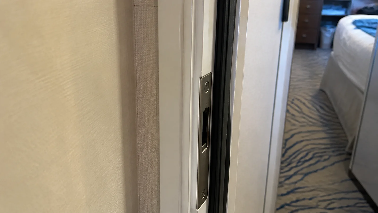 Close-up of a partially open connecting door between cruise cabins