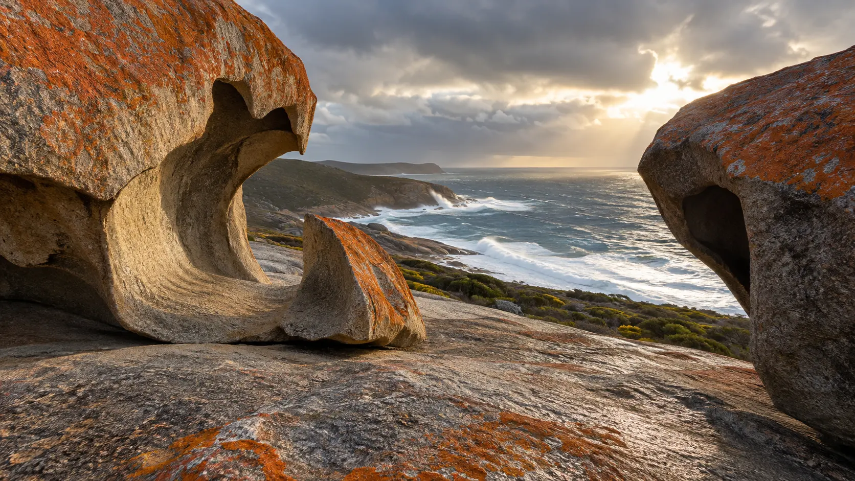 Orange-lichen-covered Remarkable Rocks frame the wild Southern Ocean on Kangaroo Island.