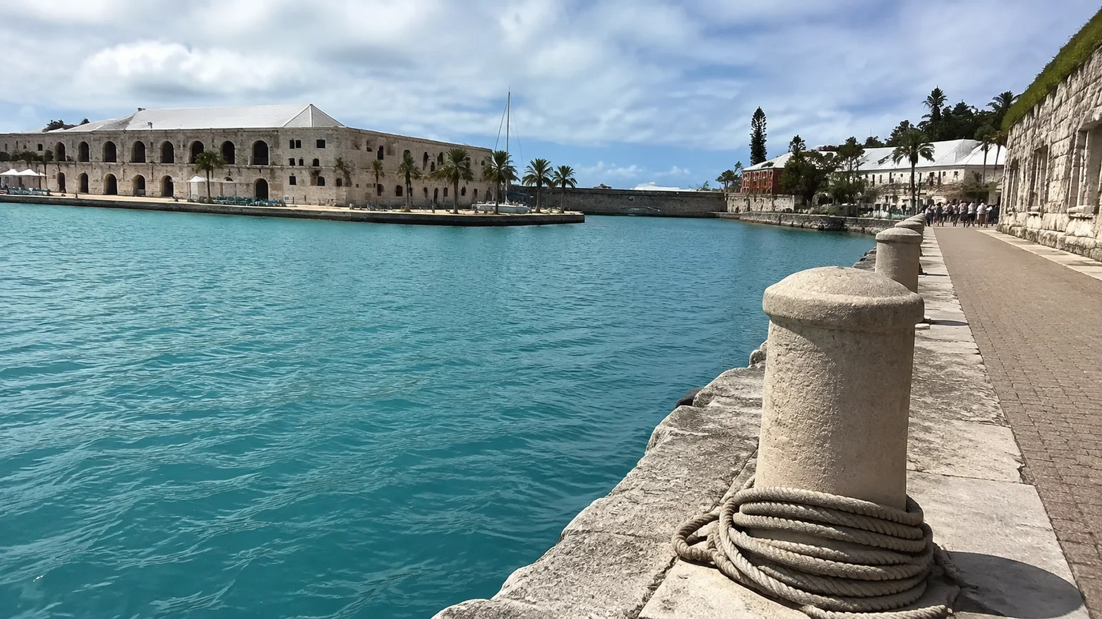 Stone waterfront wall beside turquoise water and historic buildings