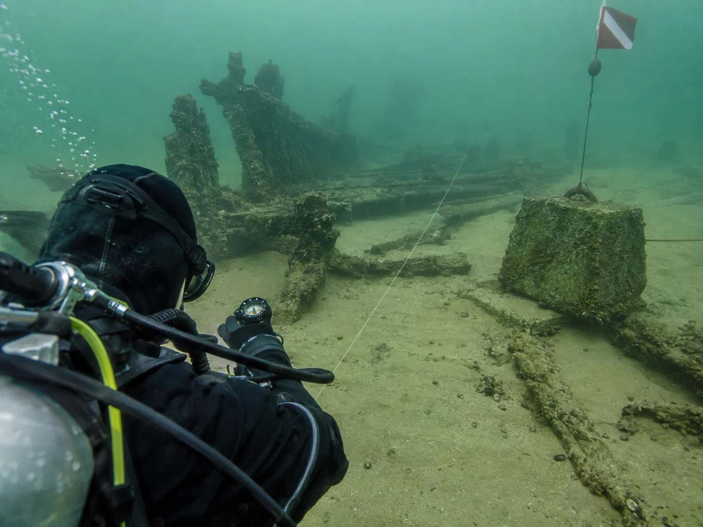 A diver uses a compass beside the shallow JD Marshall wreck in Indiana's underwater preserve.
