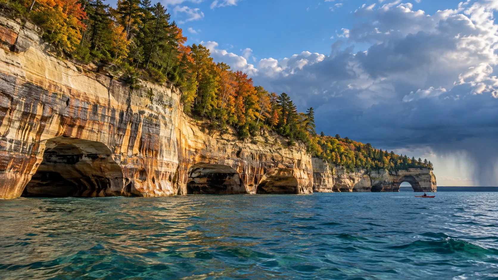 Autumn forest and colorful sandstone cliffs along Lake Superior at Pictured Rocks.