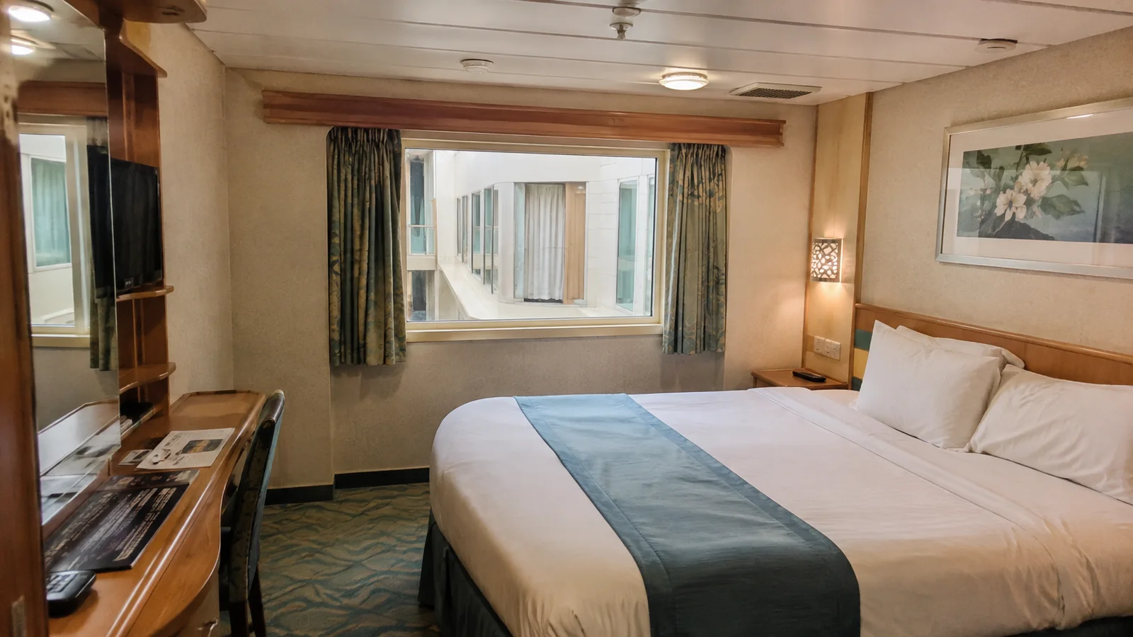 Cruise cabin with a window facing other cabin windows across an interior space.