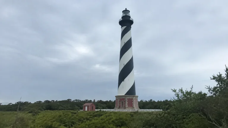 Black-and-white spiral-striped lighthouse beneath an overcast sky
