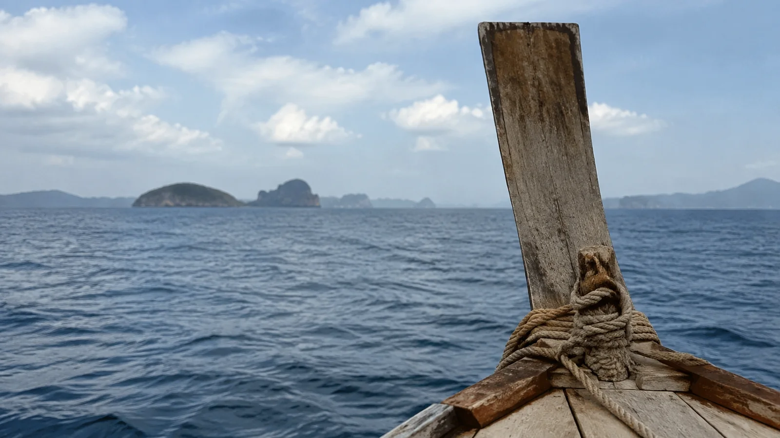 Rope tied around a wooden boat post with offshore islands beyond.