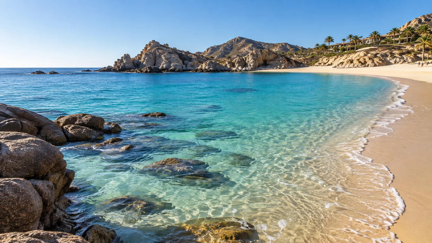 Clear turquoise water laps the sheltered crescent of Chileno Bay.