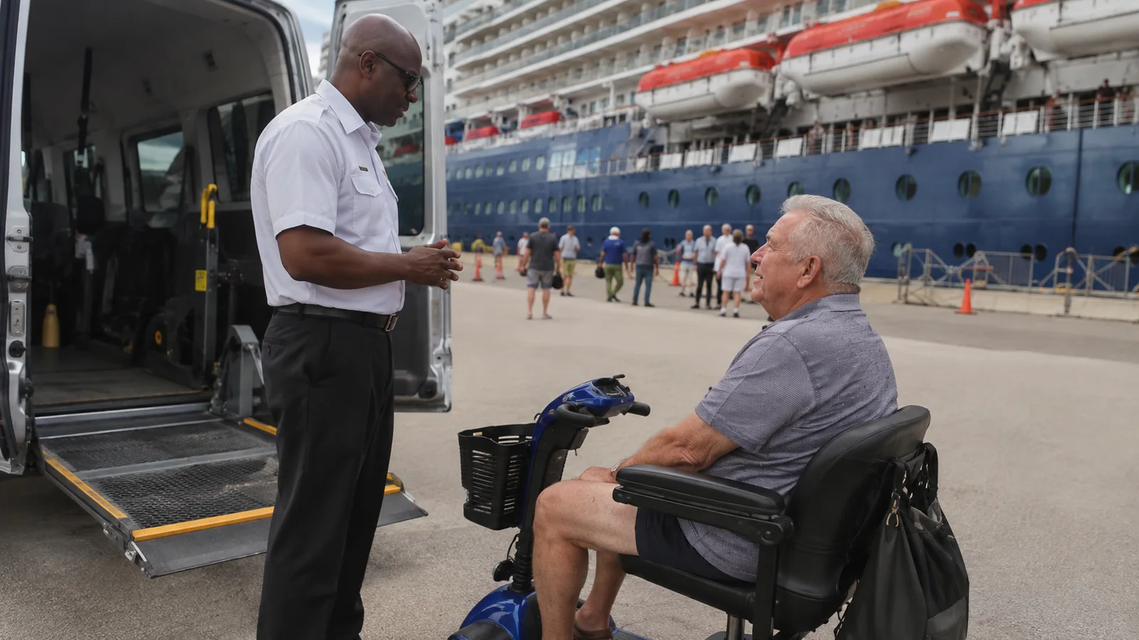 Man on a mobility scooter speaking with a staff member beside a bus.