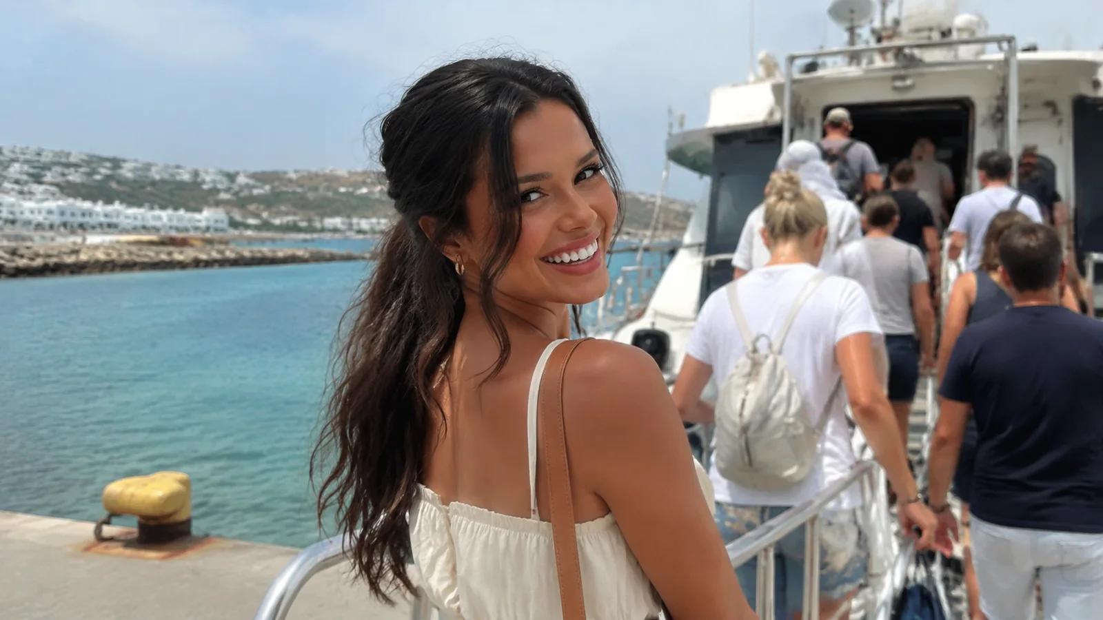 Smiling woman boarding a passenger boat with other travelers