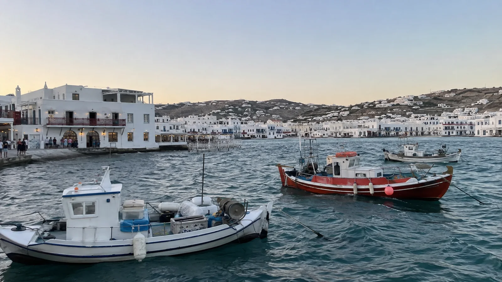 Fishing boats in a harbor lined with white waterfront buildings