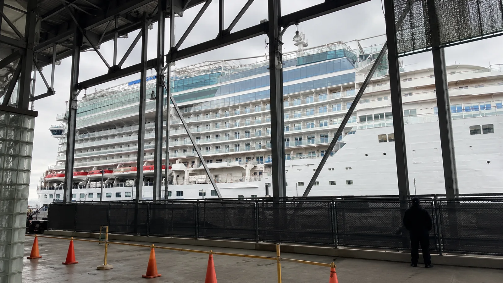 Cruise ship at a terminal framed by steel structures