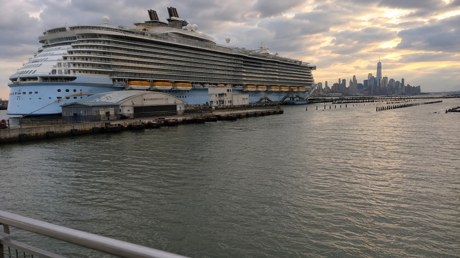 Large cruise ship docked at a terminal at sunset