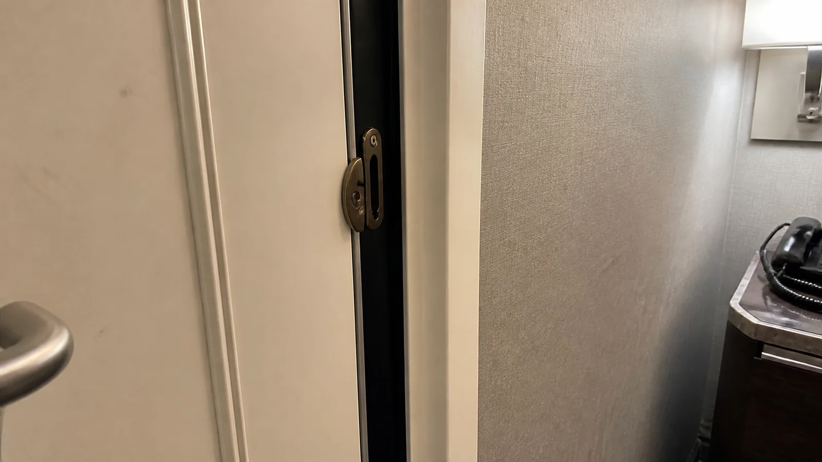 Close-up of a partially open connecting door inside a cruise cabin