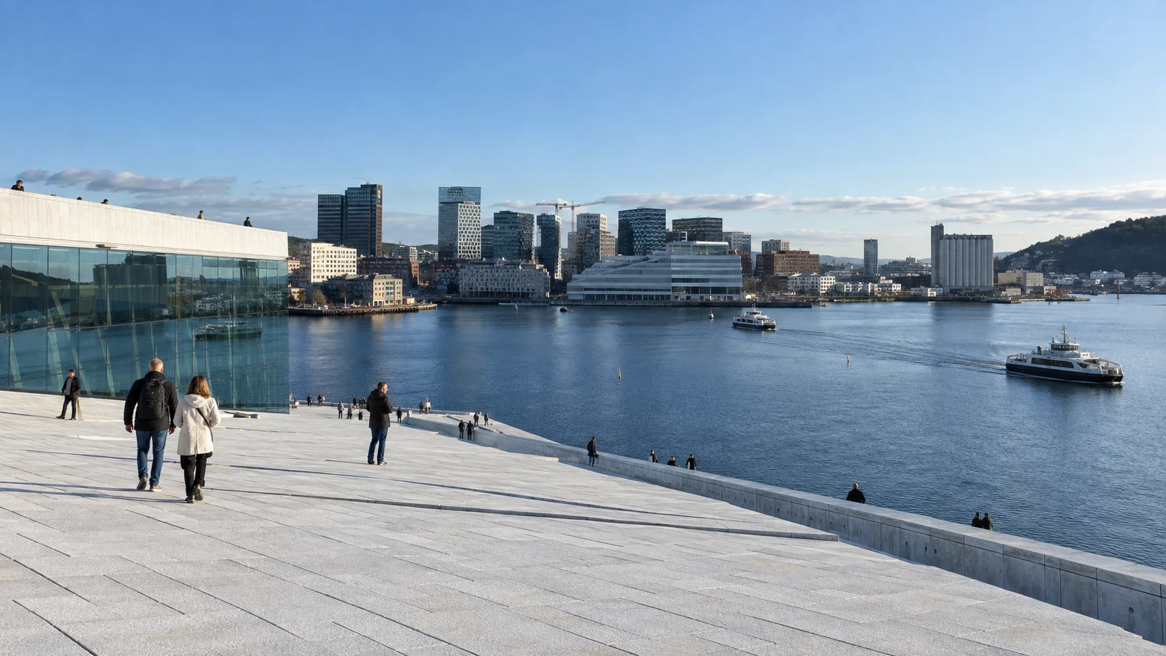 Visitors walking across the Oslo Opera House roof beside the city fjord