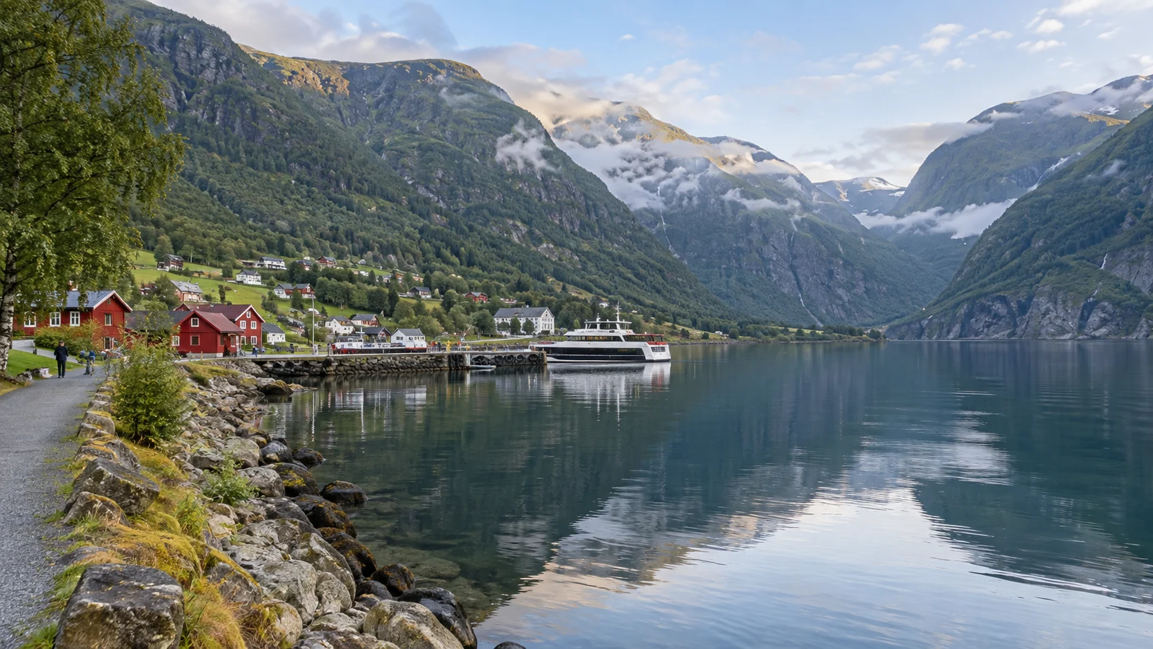 Flåm village and a passenger ferry reflected in calm Aurlandsfjord