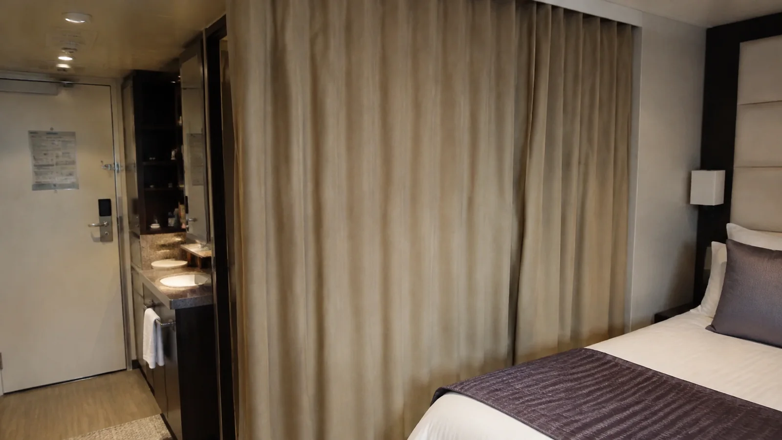 Curtain separates a stateroom sleeping area from its entryway.