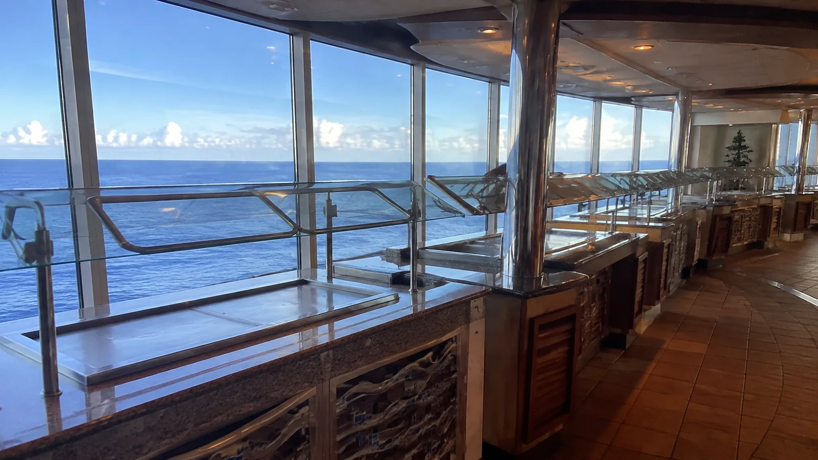 Empty buffet counters run beside a row of ocean windows.