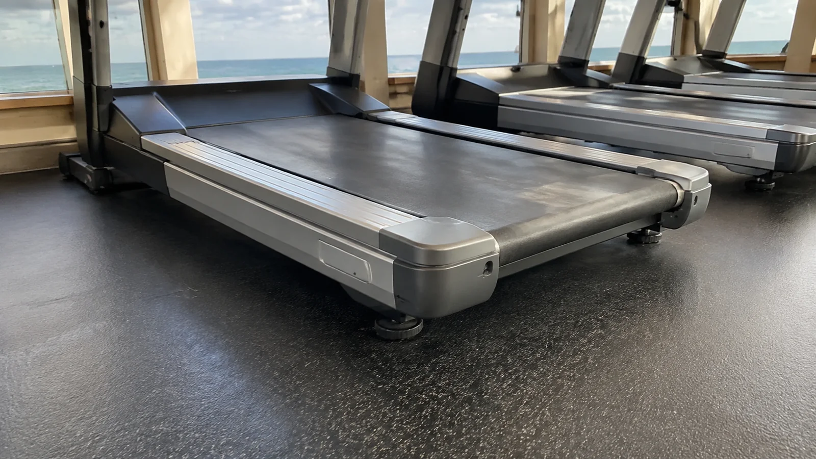 Close view of treadmill belts lined up in a fitness room.