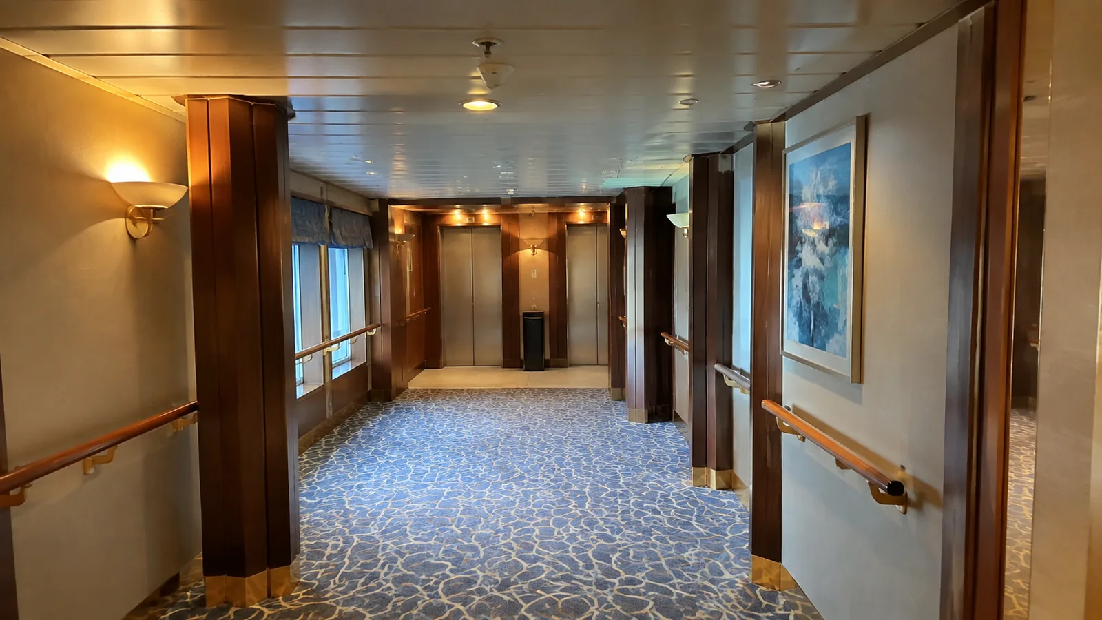 Empty carpeted ship corridor ending at closed elevator doors.