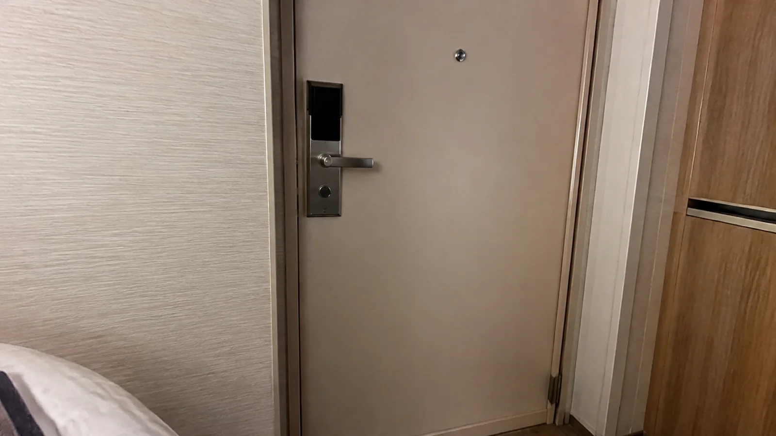 Close view of a plain stateroom door and electronic lock.