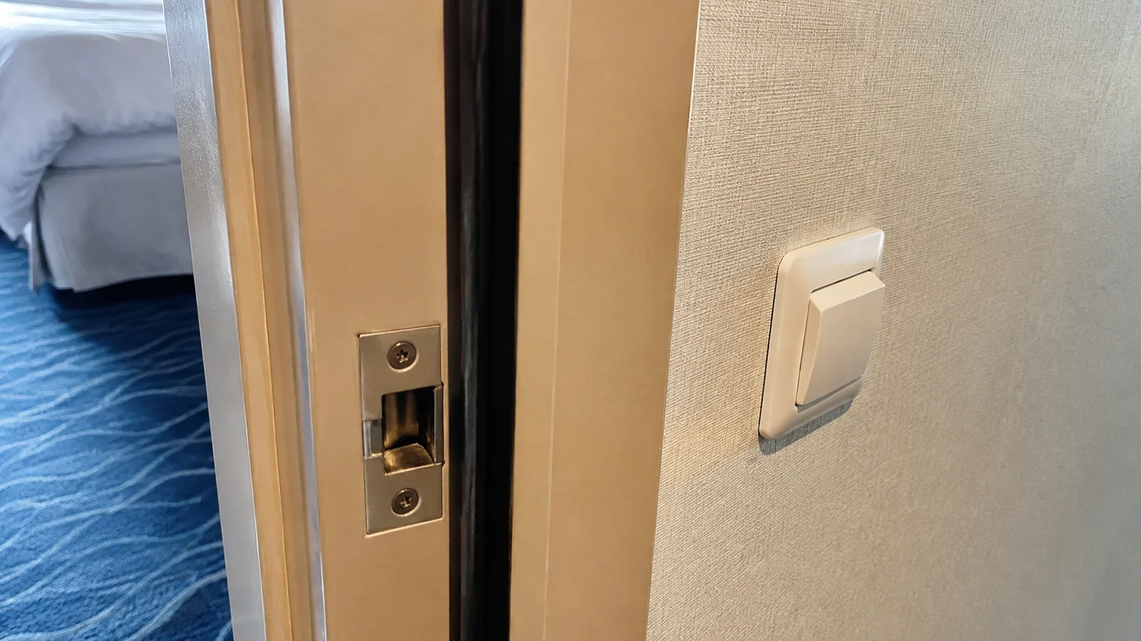Close-up of a connecting door frame and latch inside a cruise cabin