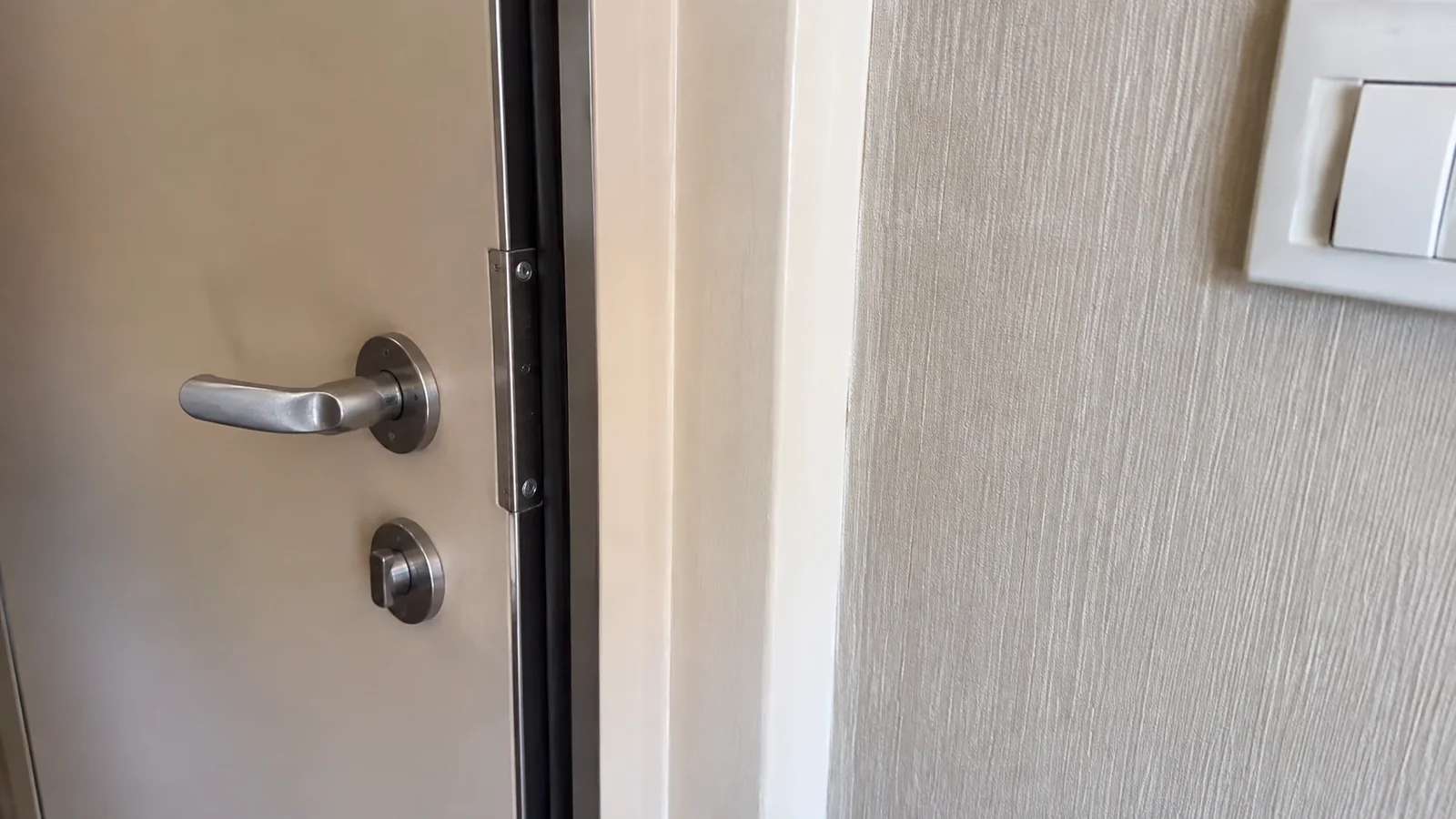 Close-up of a partially open cruise cabin door and handle
