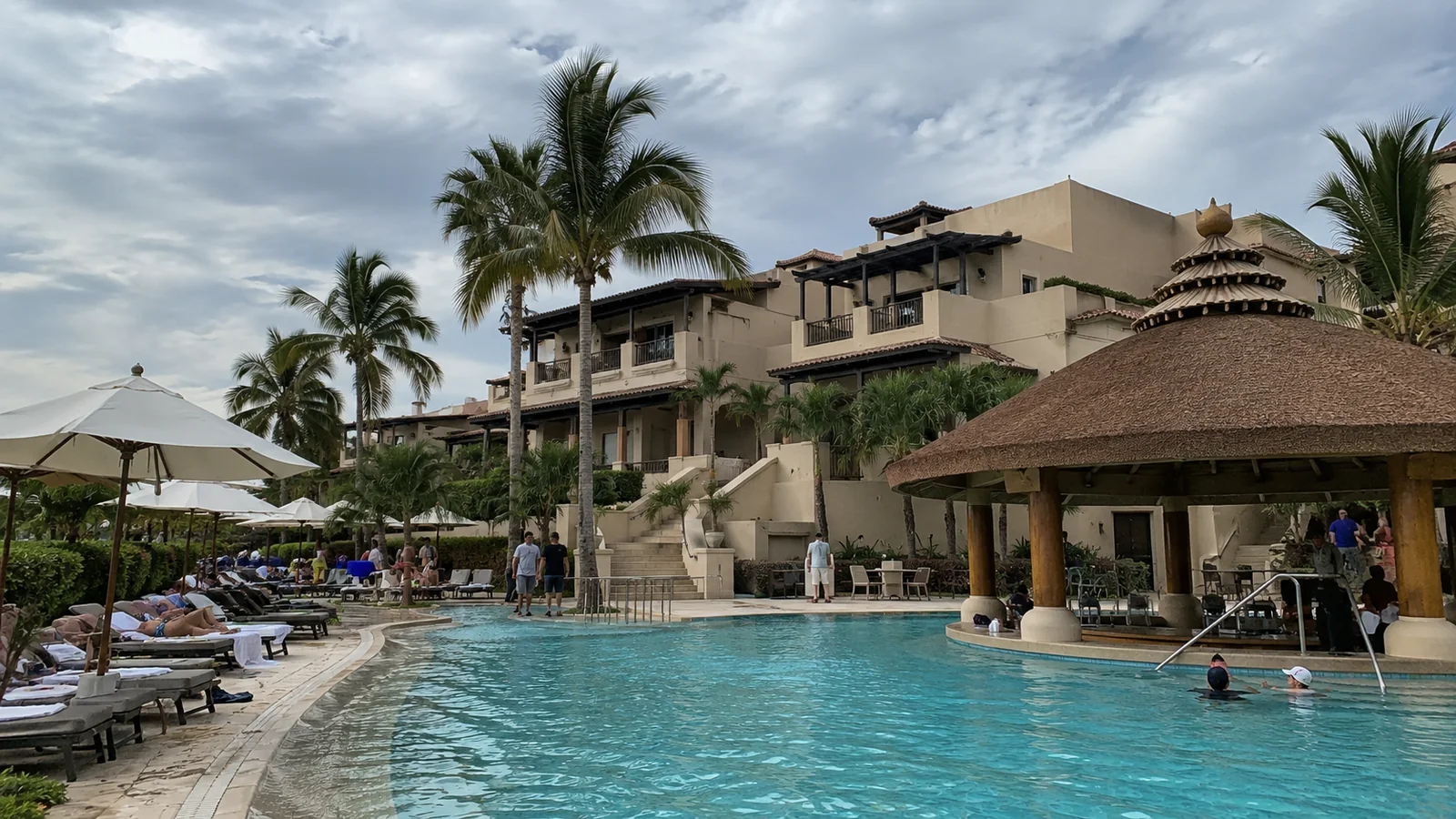 Tropical resort pool with palm trees and lounge chairs