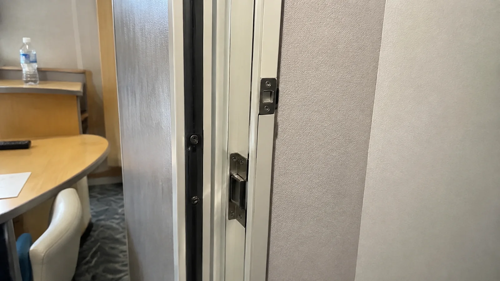 Partially open connecting door beside a cruise cabin desk
