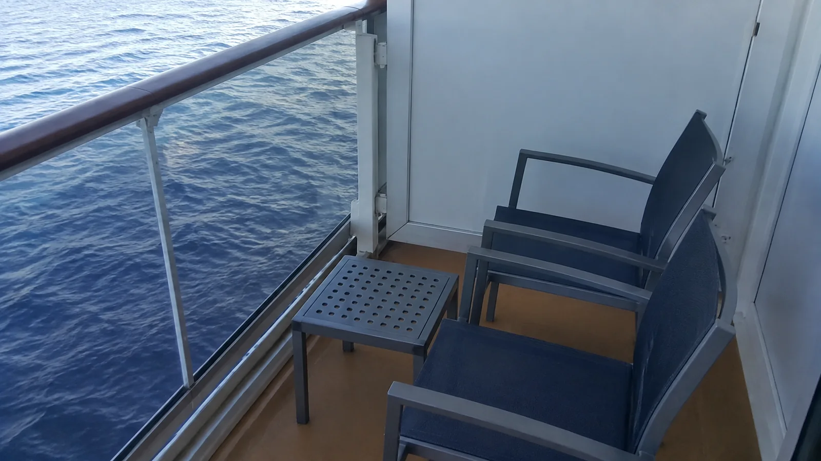 Two chairs and a small table fit on a narrow balcony.