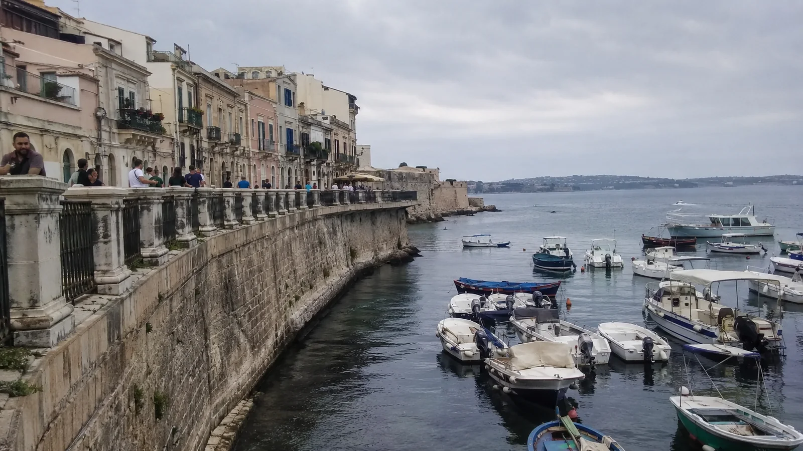 Small boats moored beside a historic stone waterfront