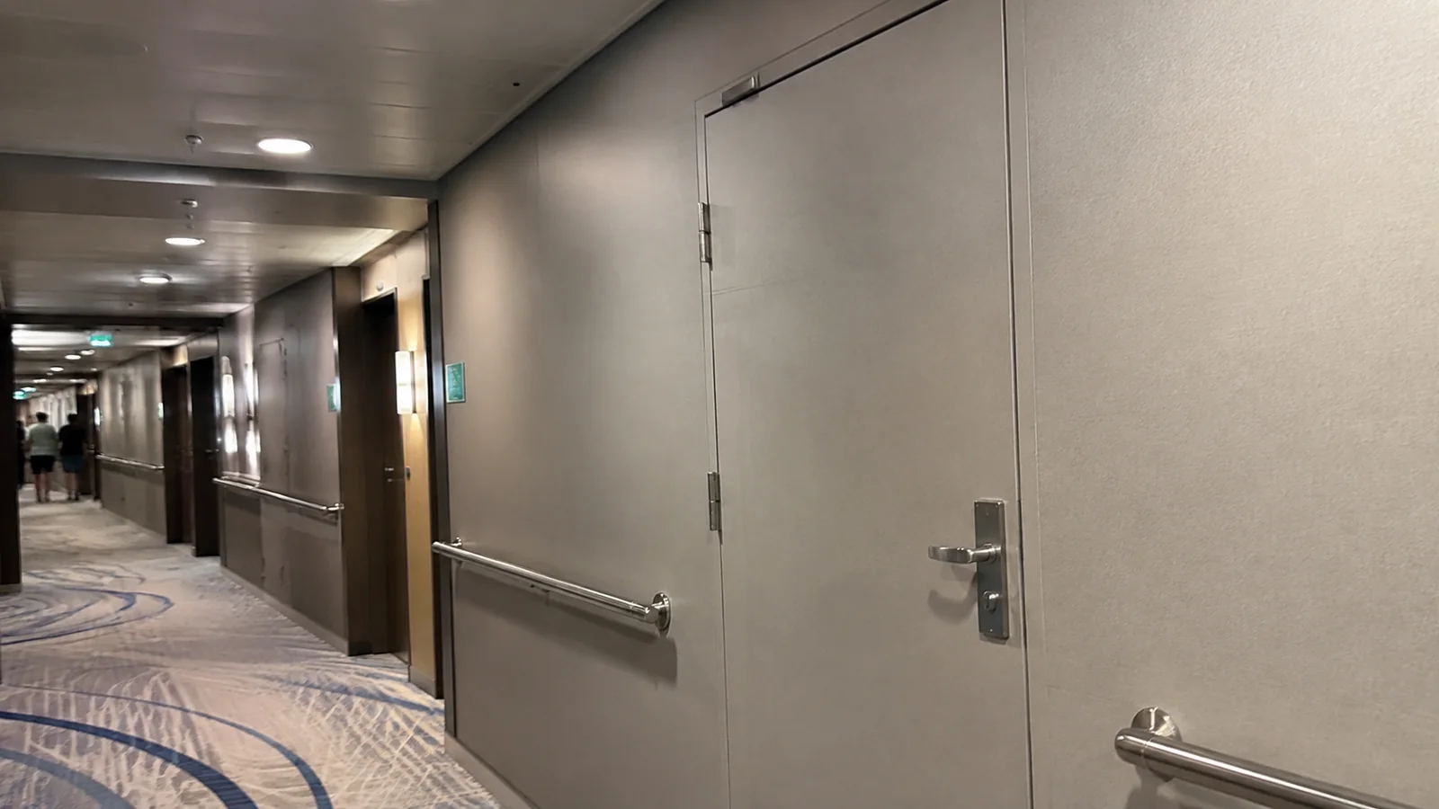 Large service doors along a carpeted cruise corridor.