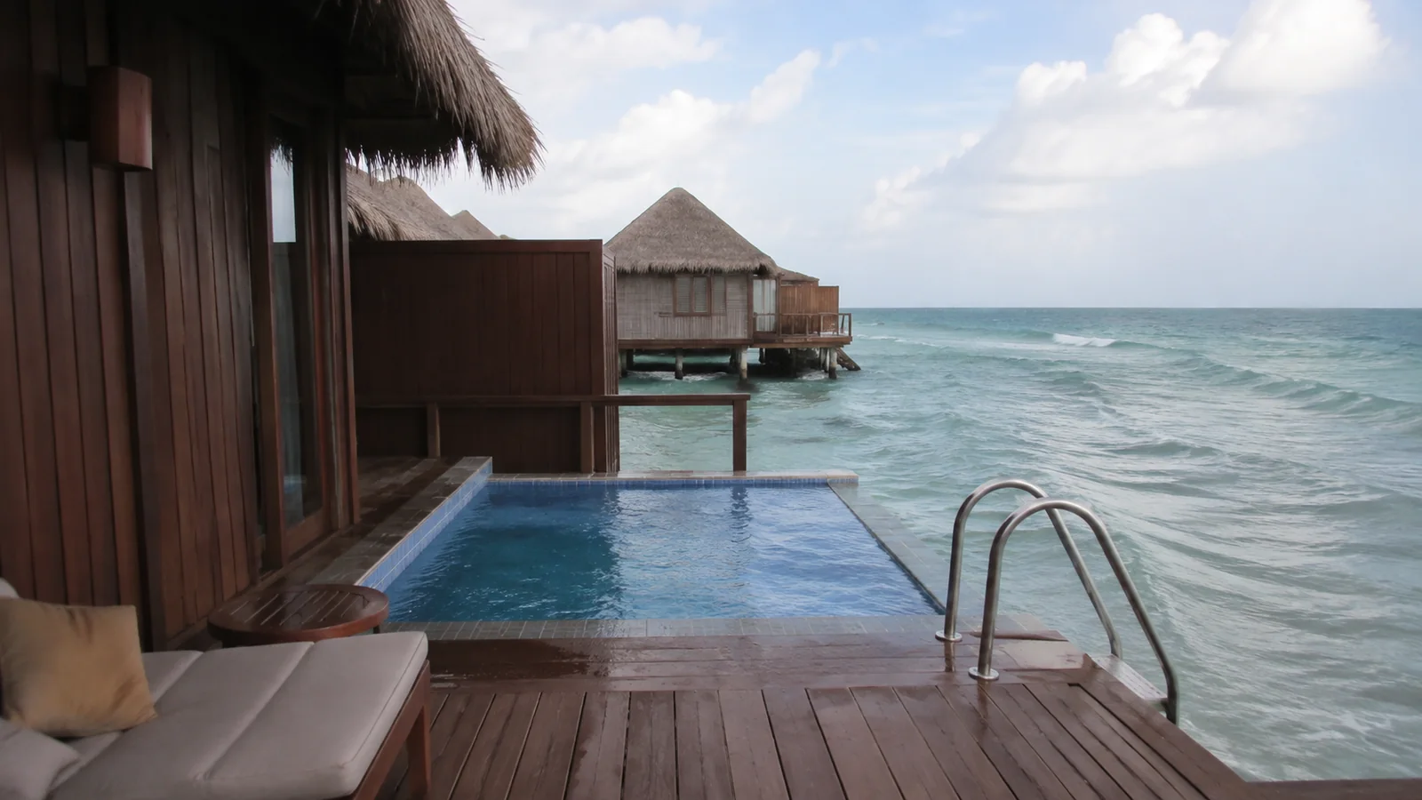 Private plunge pool and sea-access ladder on an overwater villa deck.