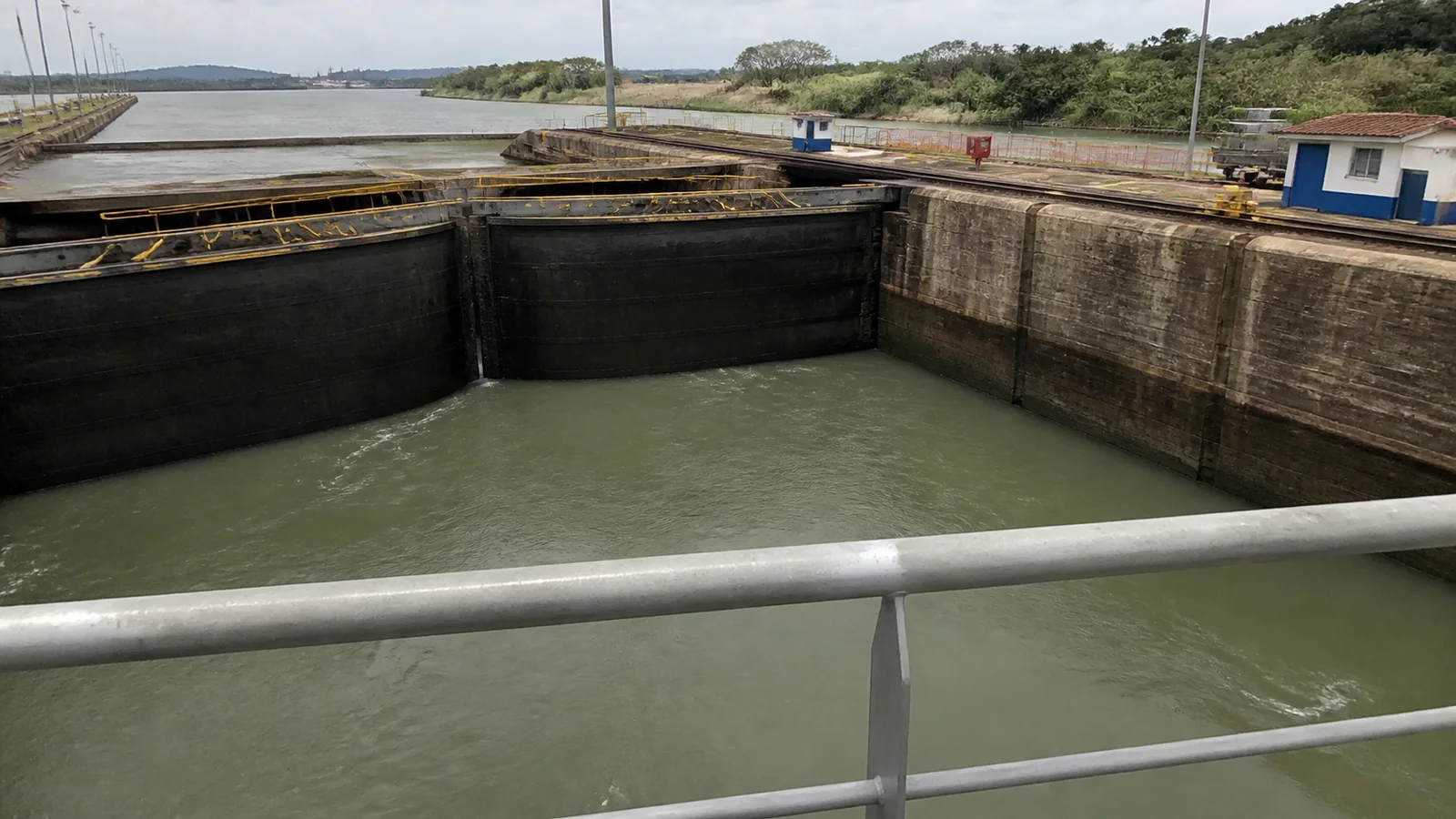 Close view of canal lock walls and gates from a ship railing.