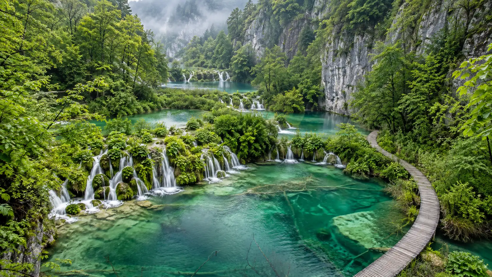 Emerald lakes cascade through spring forest in Plitvice Lakes National Park, Croatia.