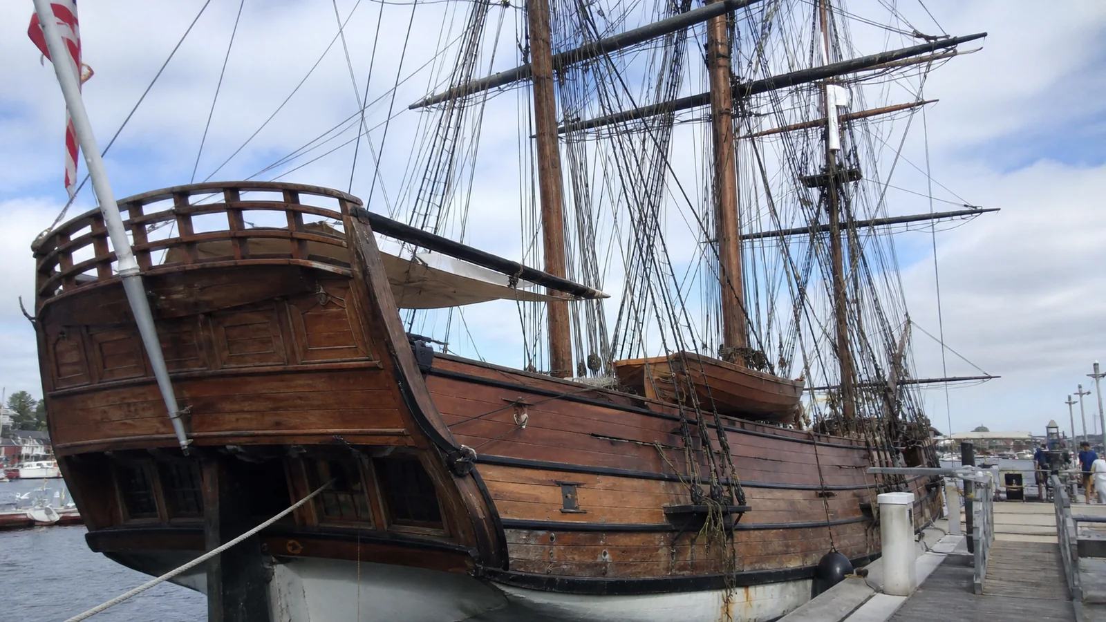 Historic wooden sailing ship with a raised stern deck and tall masts.