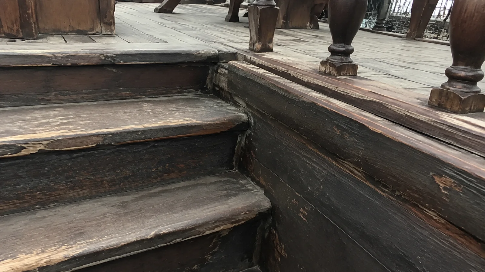 Worn wooden steps leading to a raised deck.