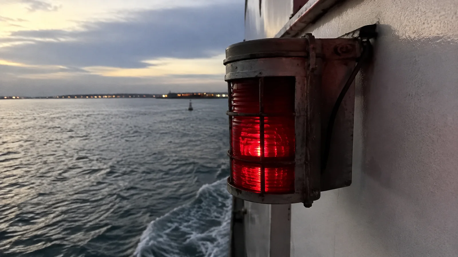 Red navigation light mounted on the side of a vessel.