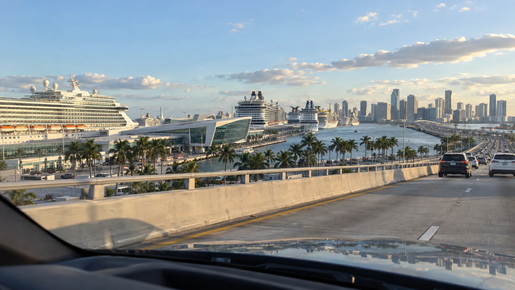 Multiple cruise ships and downtown Miami seen from a car approaching PortMiami.