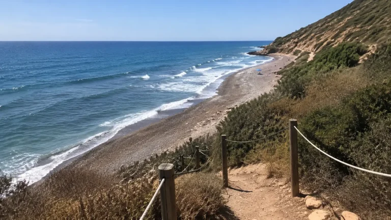 Rugged coastal path overlooking a long beach and blue ocean