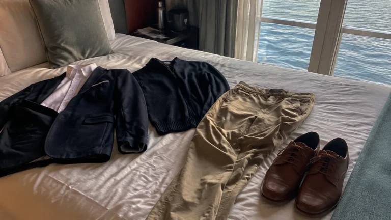 Jacket, shirts, trousers and leather shoes laid out on a cabin bed.