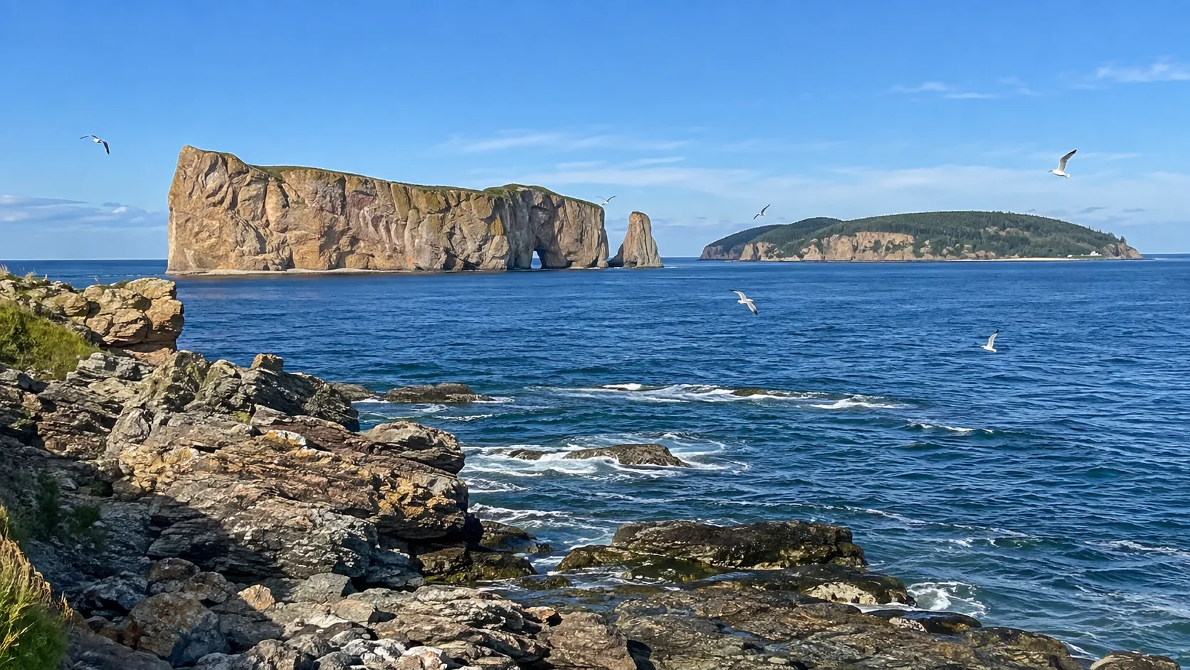 Percé Rock and Bonaventure Island beyond the rocky Gaspé coastline.