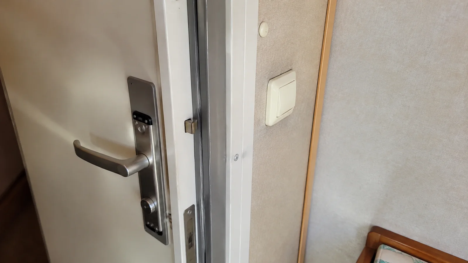 Close-up of an open connecting door and handle inside a cruise cabin