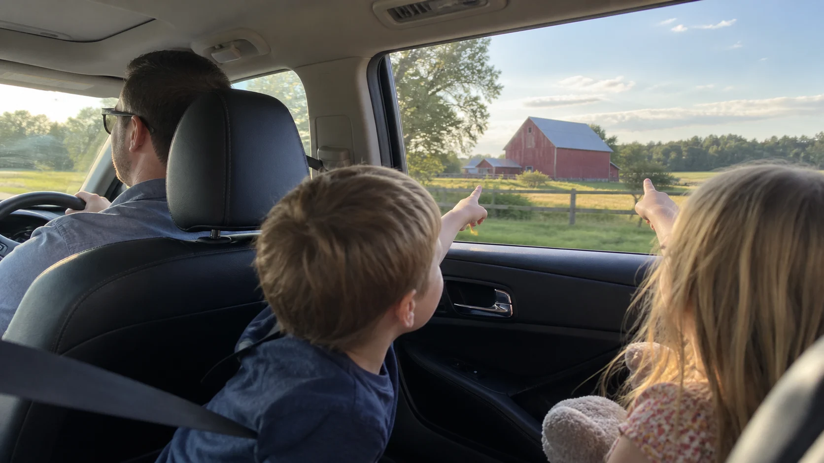 Family passengers playing I Spy during a scenic road trip.