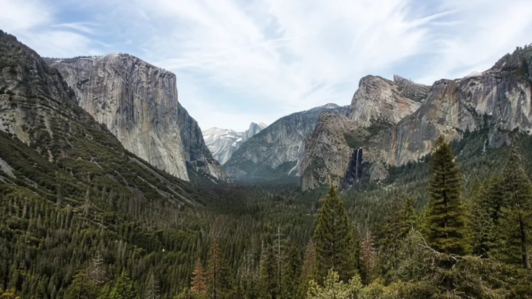Forested valley lies between towering granite cliffs