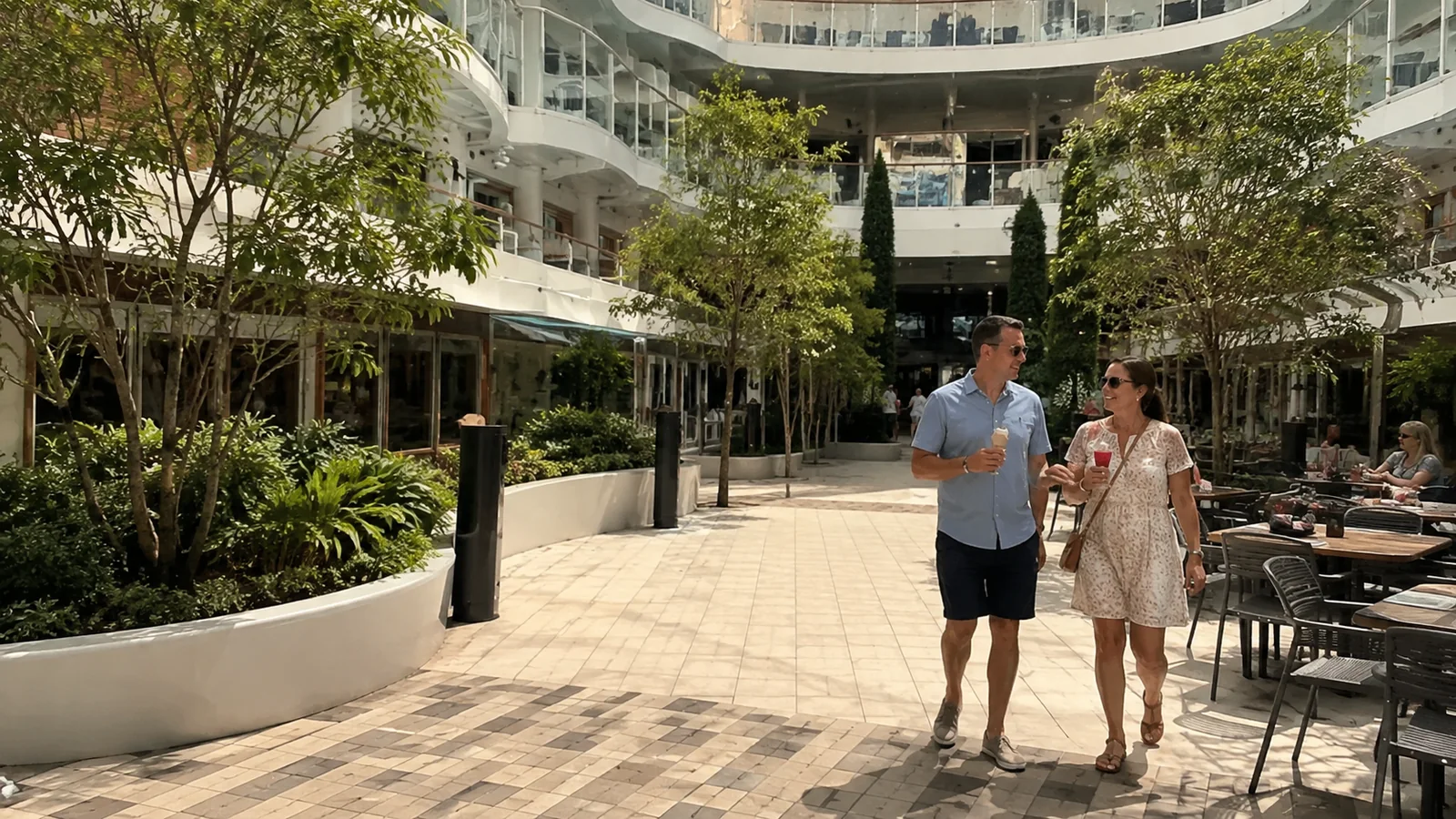 Couple walks through a planted outdoor courtyard on a cruise ship.