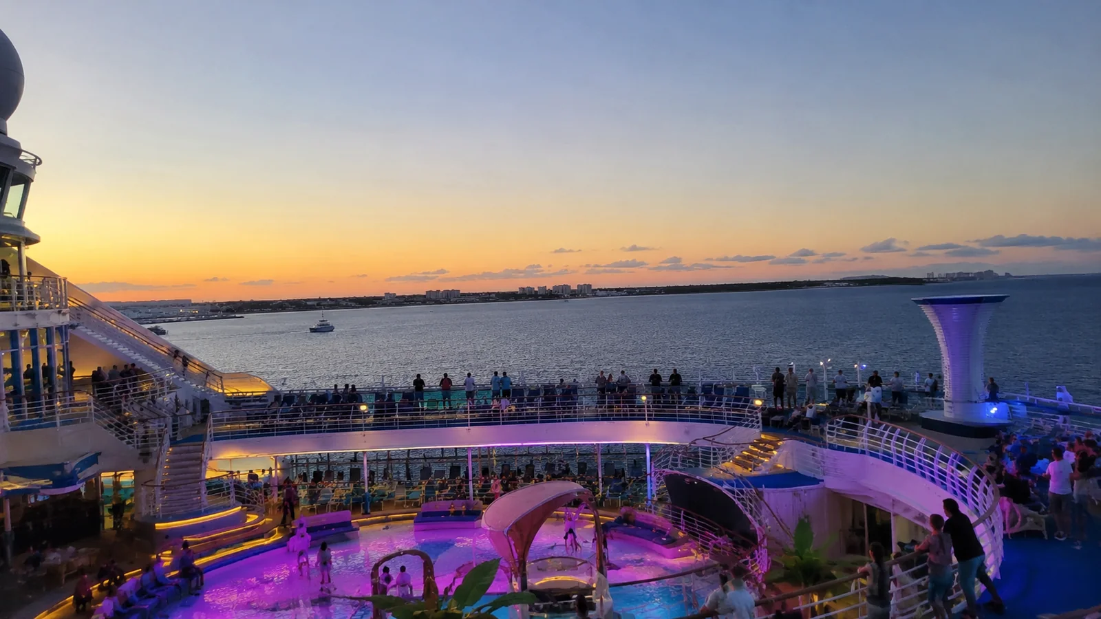 Illuminated cruise ship activity deck overlooking the ocean at sunset