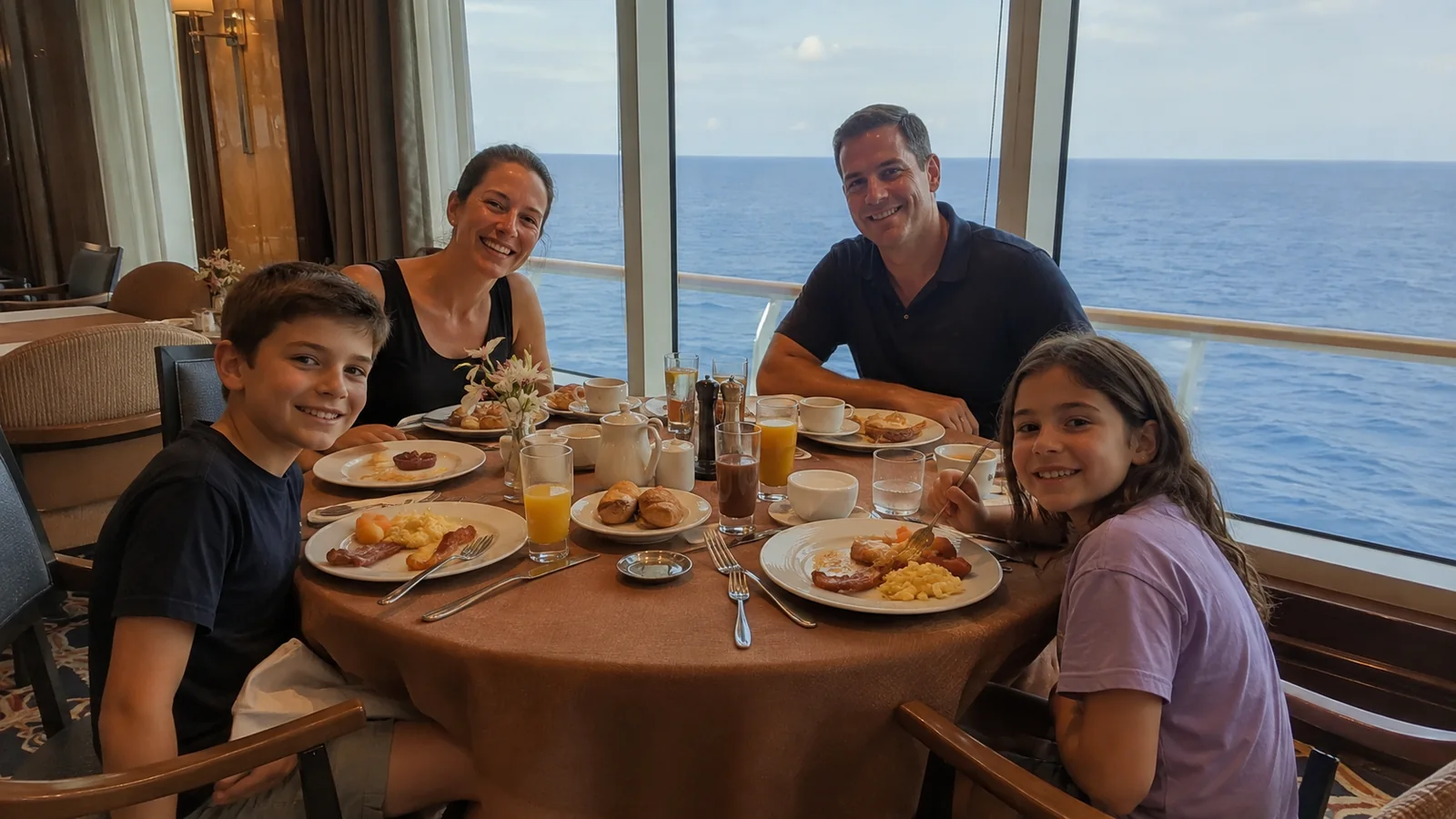 Family of four shares breakfast beside a ship window.