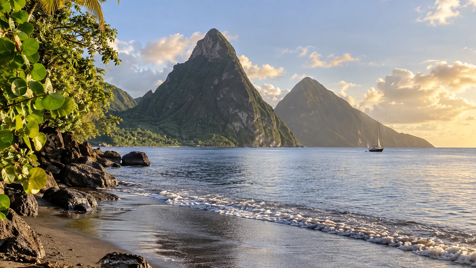 The twin Pitons rising above a quiet volcanic beach at golden hour in Saint Lucia