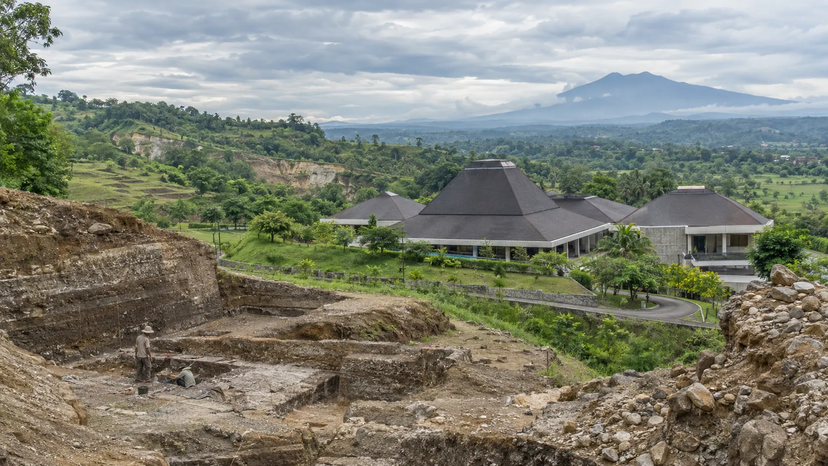 Archaeological trenches overlook the Sangiran museum and green fossil landscape in Central Java.