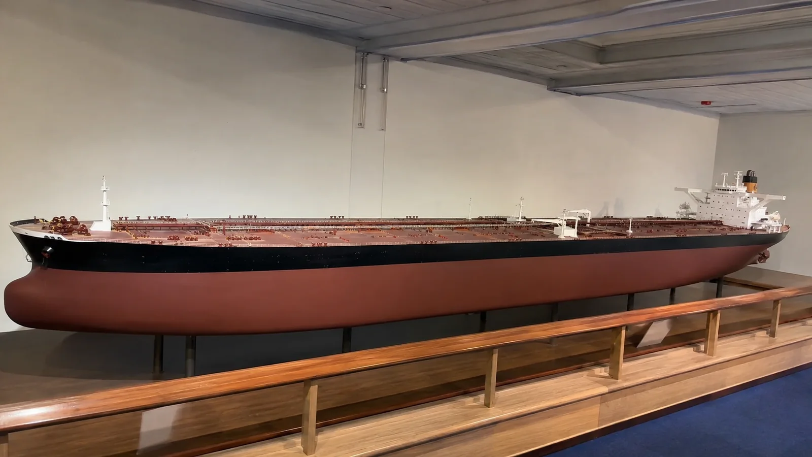 Long scale model of an oil tanker displayed in a museum.